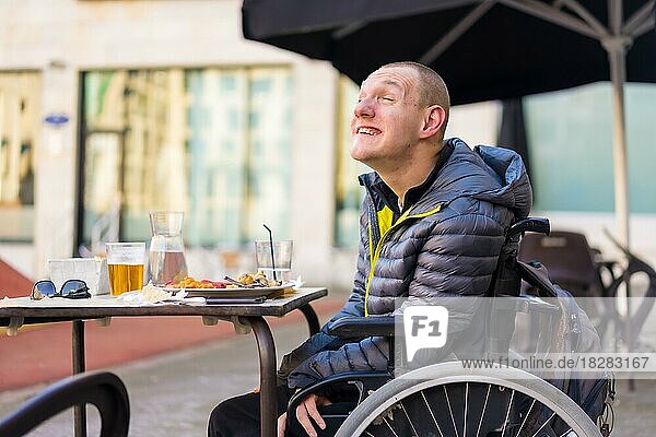 Porträt einer behinderten Person im Rollstuhl in einem Restaurant  Normalität von behinderten Menschen