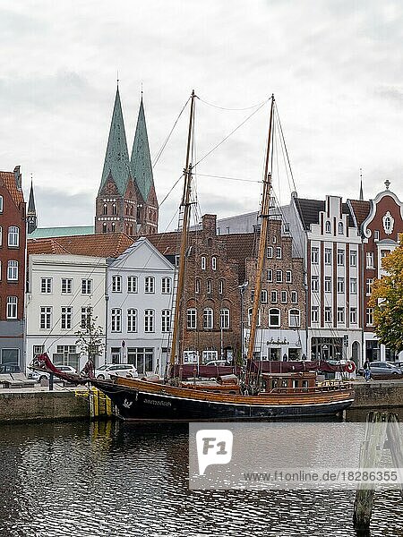 Historische Segelschiffen am Ufer der Trave und dahinter die Backsteinbauten Alte Hansehäuser in der Unesco-Welterbestätte Lübeck  Hansestadt Lübeck  Lübeck  Schleswig-Holstein  Deutschland  Europa