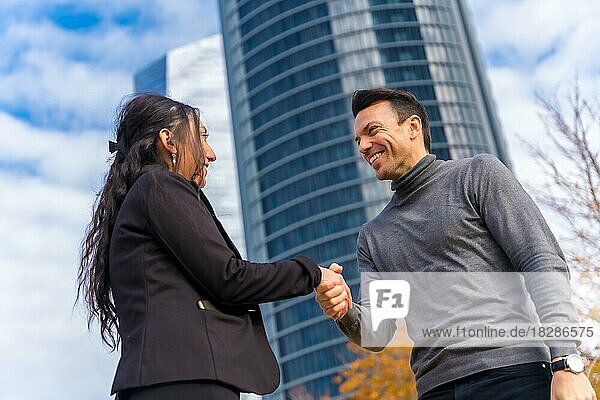 Multiethnischer Geschäftsmann und Geschäftsfrau  Begrüßung durch Händeschütteln und Lächeln