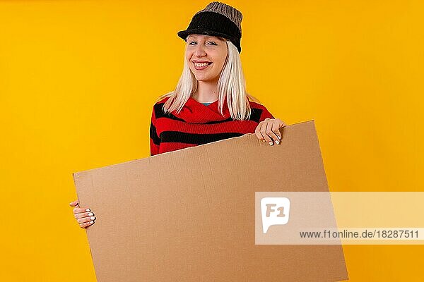 Halten leeren Karton Werbeplakat  blonde kaukasische Mädchen auf gelbem Hintergrund Studio