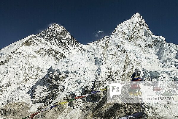 Classic view of Mount Everest  also called Chomolungma or Sagarmatha  from Kala Patthar  the famous trekking peak and viewpoint in the Himalayas. Colourful Buddhist prayer flags are in the foreground. South Col is to the right of Everest  and the ridge rises from it to the top of another eight-thousander: Lhotse. Nuptse looks spectacular on the right-hand side of the image with its sharp peak. Autumn trekking season in Khumbu. Sagarmatha National Park  Everest Region  Solukhumbu  Nepal  Asia