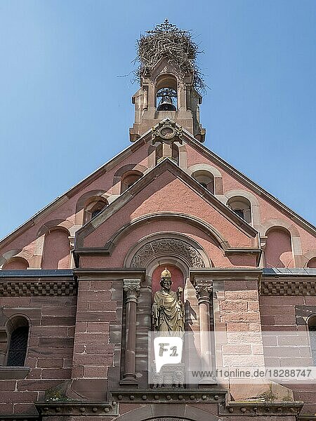 Der Dachteil der neoromanisch-byzantinischen St. Leo-Kapelle mit einem Storchennest auf dem Glockenturm und einer Skulptur an der Wand  Eguisheim  Haut-Rhin  Alsace  Elsass  Frankreich  Europa