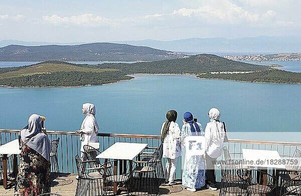 Türkische Frauen mit Kopftüchern blicken vom Satan's Tisch auf den Ayvalik-Inseln Nationalpark im Ägäischen Meer  Ayvalik  Provinz Bal?kesir  Türkei  Asien