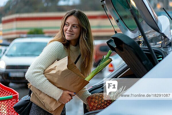Frau mit Einkauf im Supermarkt auf dem Parkplatz  vegetarisches Essen  erreicht Auto