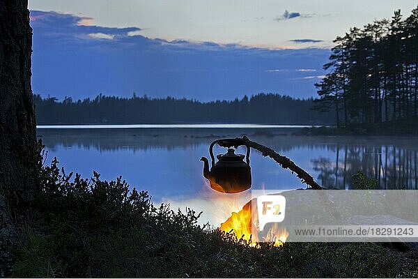 Kessel zum Kaffeekochen  der über einem offenen Lagerfeuer am See bei Sonnenuntergang erhitzt wird  Dalarna  Schweden  Europa