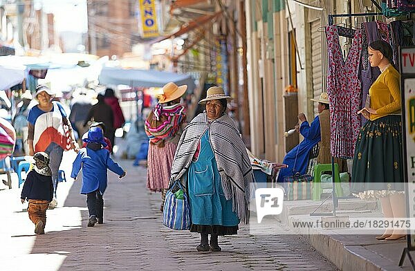 Aymara-Frau in traditioneller Kleidung spaziert durch eine Einkaufsstraße in Copacabana  Departamento La Paz  Provinz Provinz Manco Kapac  Bolivien  Südamerika