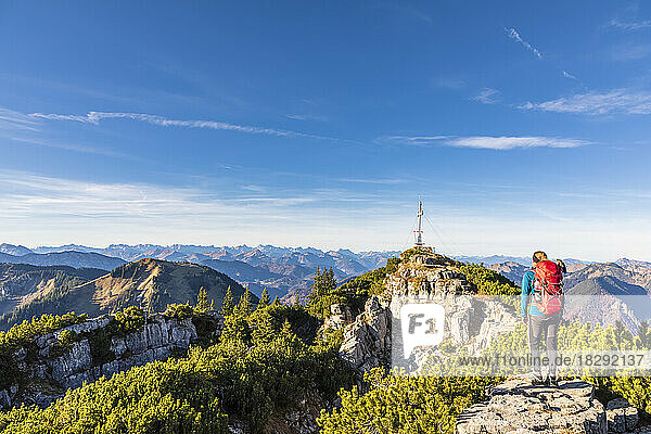 Germany  Bavaria  Female hiker admiring surrounding landscape from summit of Wallberg mountain