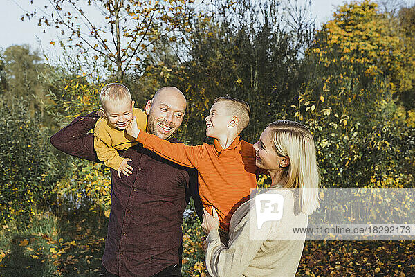 Smiling parents with children enjoying in autumn