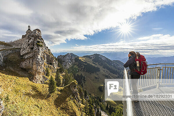 Germany  Bavaria  Female hiker looking toward Wendelstein mountain from observation platform
