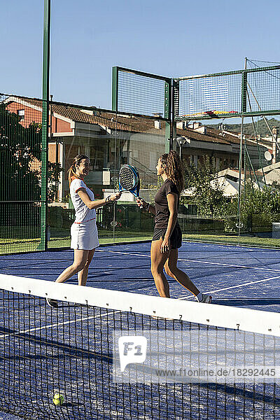 Frauen mit Tennisschlägern spielen auf dem Sportplatz