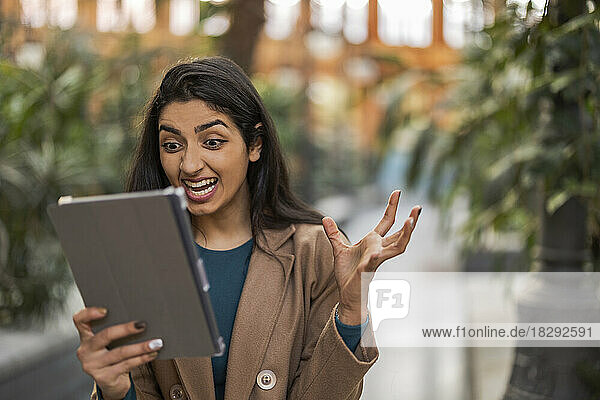 Young woman gesturing on video call over tablet PC