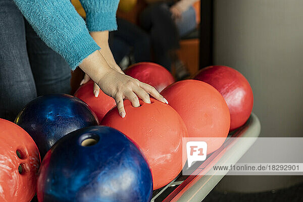 Hand of woman lifting bowling ball