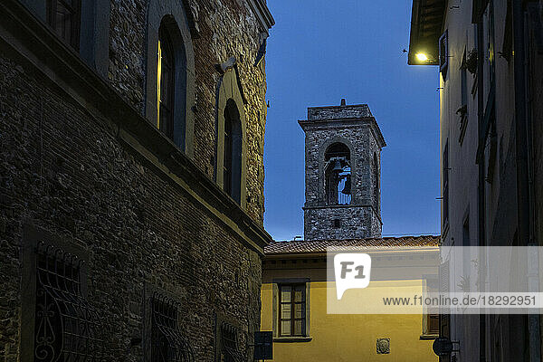 Glockenturm und Häuser in der Stadt Bibbiena in der Abenddämmerung