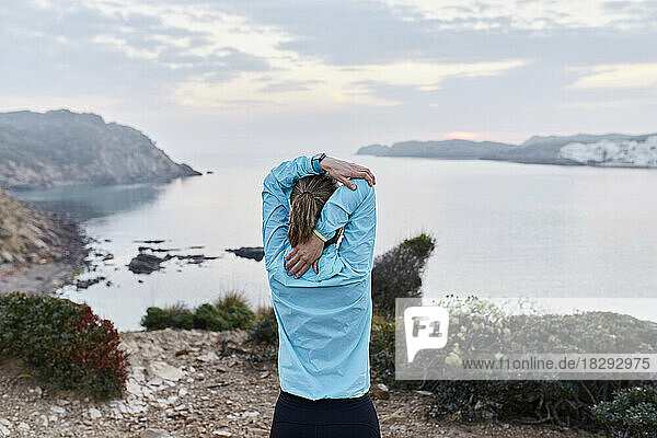 Woman doing stretching in front of sea