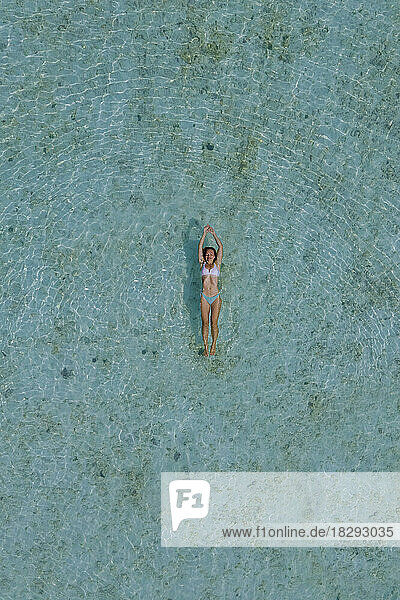 Drone view of woman swimming in turquoise sea