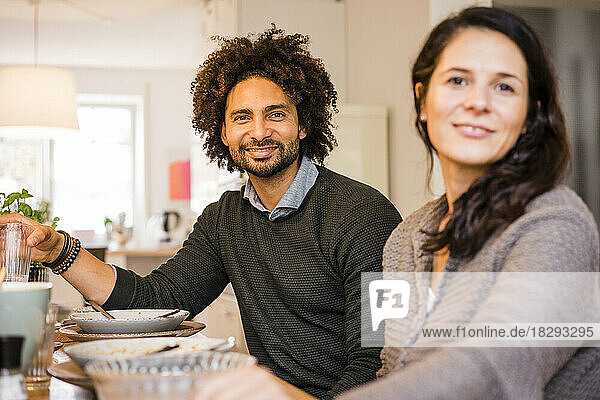 Happy man and woman sitting at dining table