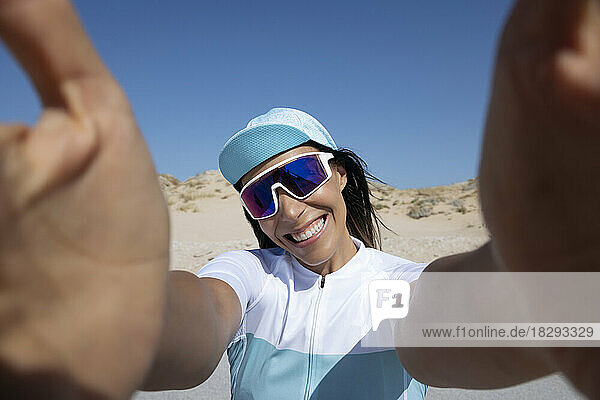 Happy mature cyclist taking selfie on sunny day
