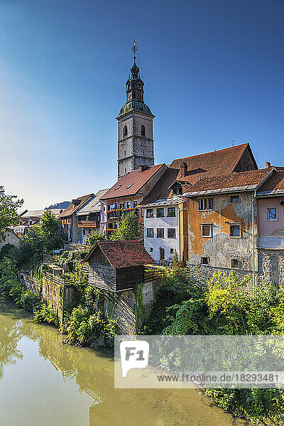 Slovenia  Upper Carniola  Skofja Loka  Riverside houses with bell tower of St. Jacob Church in background