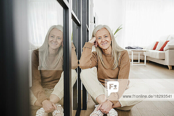 Mature woman by glass door in living room