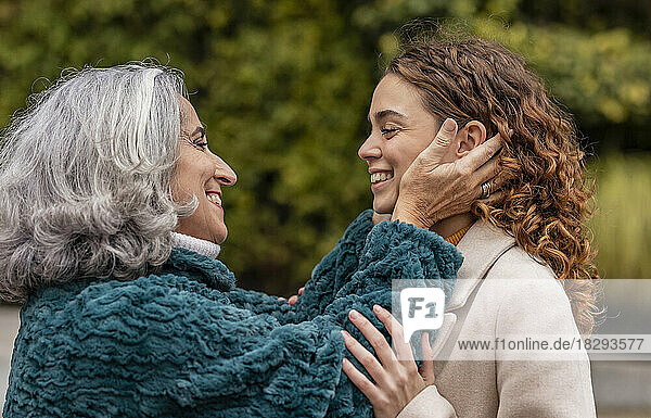 Happy grandmother embracing granddaughter in park