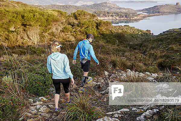 Trail runner couple moving down on mountain