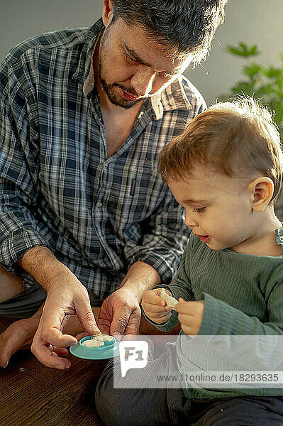 Father and son playing with clay at home