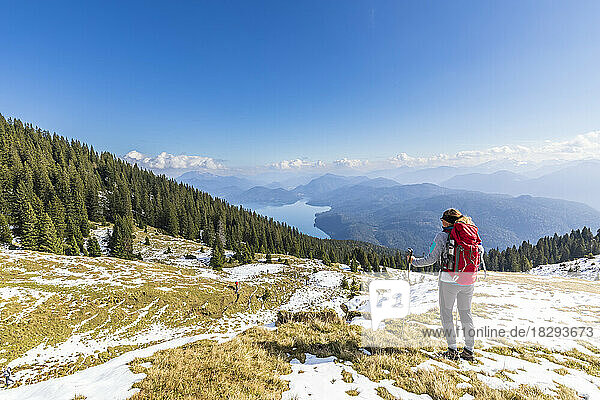 Germany  Bavaria  Female hiker looking toward Walchensee Lake seen from summit in Ester Mountains