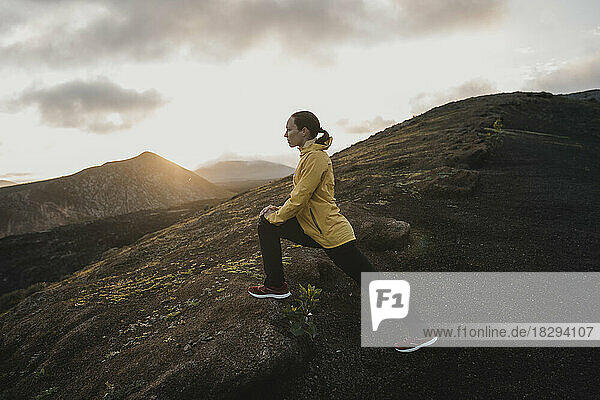 Woman doing exercising at sunrise  Caldera Blanca volcano  Lanzarote  Canary Islands  Spain