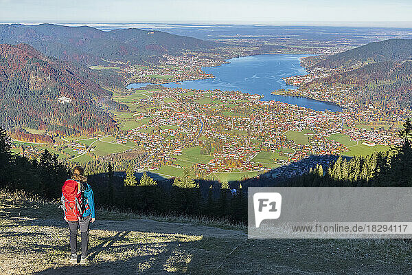 Germany  Bavaria  Rottach-Egern  Female hiker admiring view of Lake Tegernsee and surrounding towns from summit of Wallberg mountain