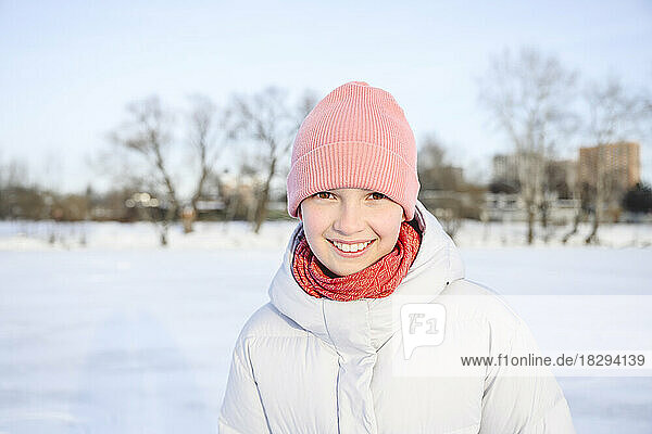 Fröhliches Mädchen mit Strickmütze im Winter