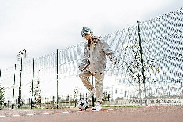 Teenage girl playing with soccer ball