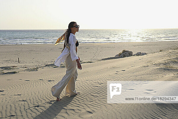 Young woman walking on sand dune at beach  Patara  Turkiye