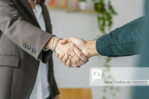 Recruiter shaking hand with candidate in office