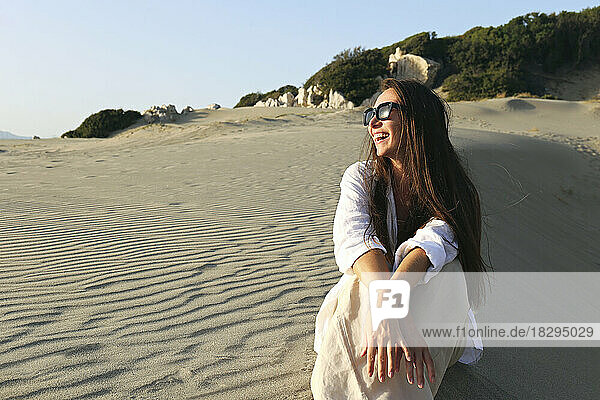 Happy young woman sitting on sand at beach  Patara  Turkiye