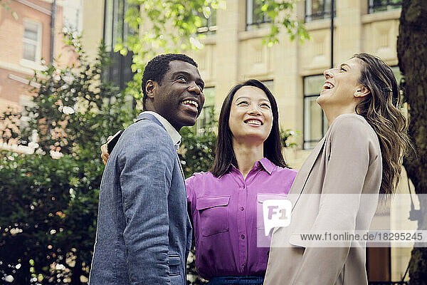 Cheerful businesswomen and businessman standing at park