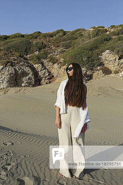 Young woman with long hair standing on sand at beach  Patara  Turkiye