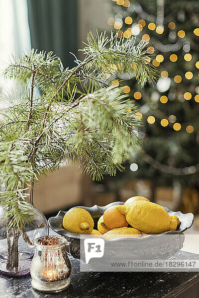 Fresh lemons in vintage bowl on wooden table at home