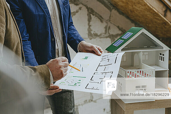 Businessman showing blueprint to colleague at construction site