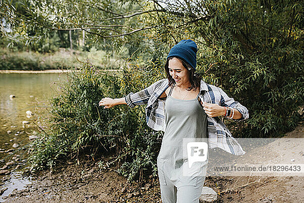 Smiling young woman wearing knit spending leisure time in park
