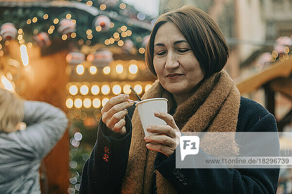 Smiling woman having coffee in winter