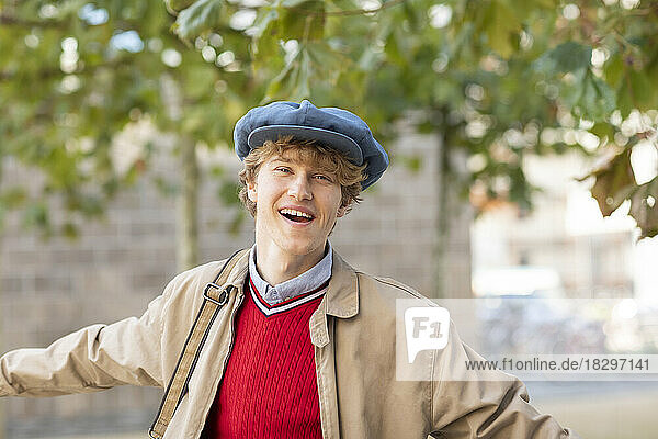 Happy young man wearing flat cap and jacket