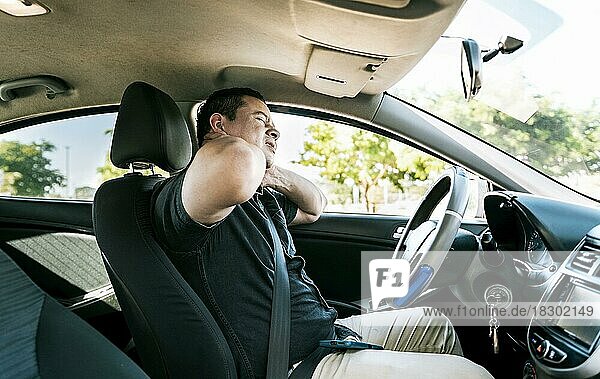 Exhausted driver with pain and stress. Man in the car with neck pain. Exhausted driver with neck pain in traffic  Driver people with neck pain in car