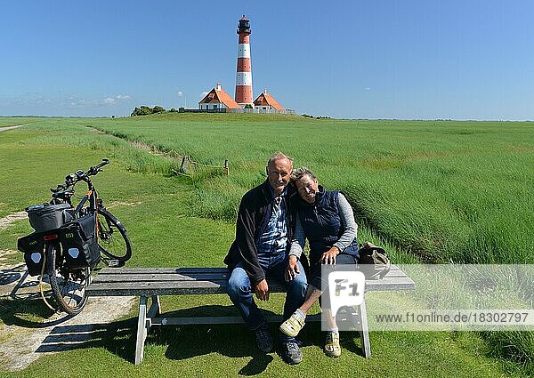 Couple sitting on a bench at Westerheversand lighthouse  Schleswig-Holstein  Germany  Europe