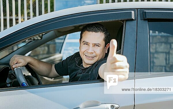 Happy Driver giving a thumbs up. Satisfied driver man showing thumb up. Concept of satisfied car owner  Man in his car giving thumbs up