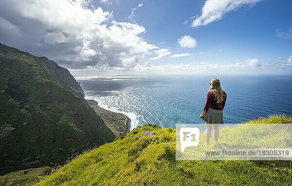 Young woman enjoying view of cliffs and sea  coastal landscape  viewpoint Ponta da Leideira  near Calhau das Achadas  Madeira  Portugal  Europe