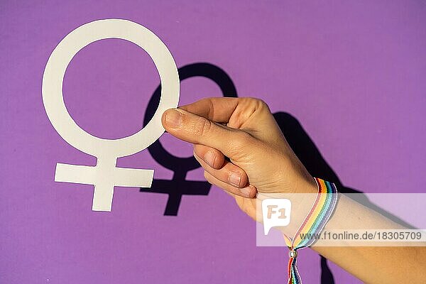 Hand eines mu hält ein weibliches Symbol Zeichnung  lila Hintergrund  kämpfen zugunsten der Frauen  weibliche Stärke  LGTB Flagge