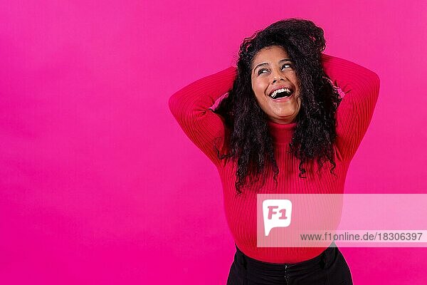 Gelockte Frau lächelnd auf einem rosa Hintergrund  Studioaufnahme  Lifestyle