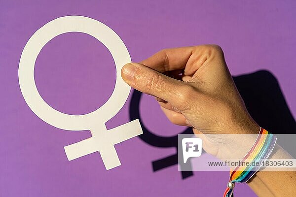 Hand eines mu hält ein weibliches Symbol Zeichnung  lila Hintergrund  kämpfen zugunsten der Frauen  weibliche Stärke  LGTB Flagge