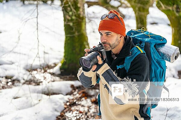Fotograf beim Fotografieren im Winter in einem verschneiten Wald