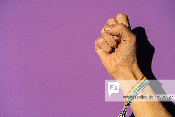 Hand einer Frau mit Faust geschlossen hart auf Kampf Symbol zugunsten des Feminismus  lila Hintergrund  kämpfen zugunsten der Frauen  weibliche Stärke  LGTB Flagge